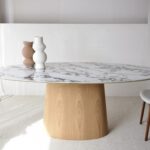 Mesa de comedor oval de sobre cerámico blanco con base fresno natural