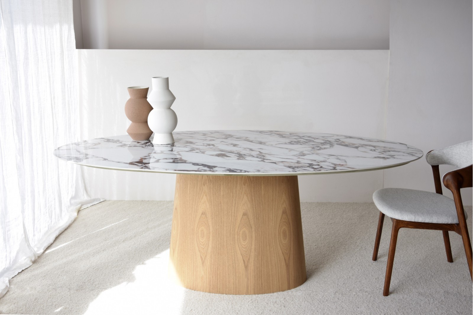 Mesa de comedor oval de sobre cerámico blanco con base fresno natural