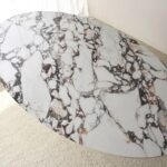 Mesa de comedor oval de sobre cerámico blanco con base fresno natural