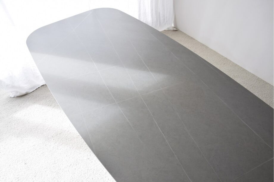 Mesa de comedor oval de sobre cerámico gris con patas fresno