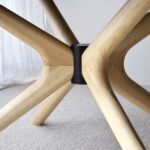 Mesa de comedor oval de sobre cerámico gris con patas fresno