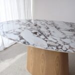 Mesa de comedor oval de sobre cerámico blanco con base fresno natural
