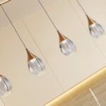 Lámpara CORINA en línea de 5 colgantes negra con detalles cobre y cristal transparente de 30W Led integrado dimable Schuller